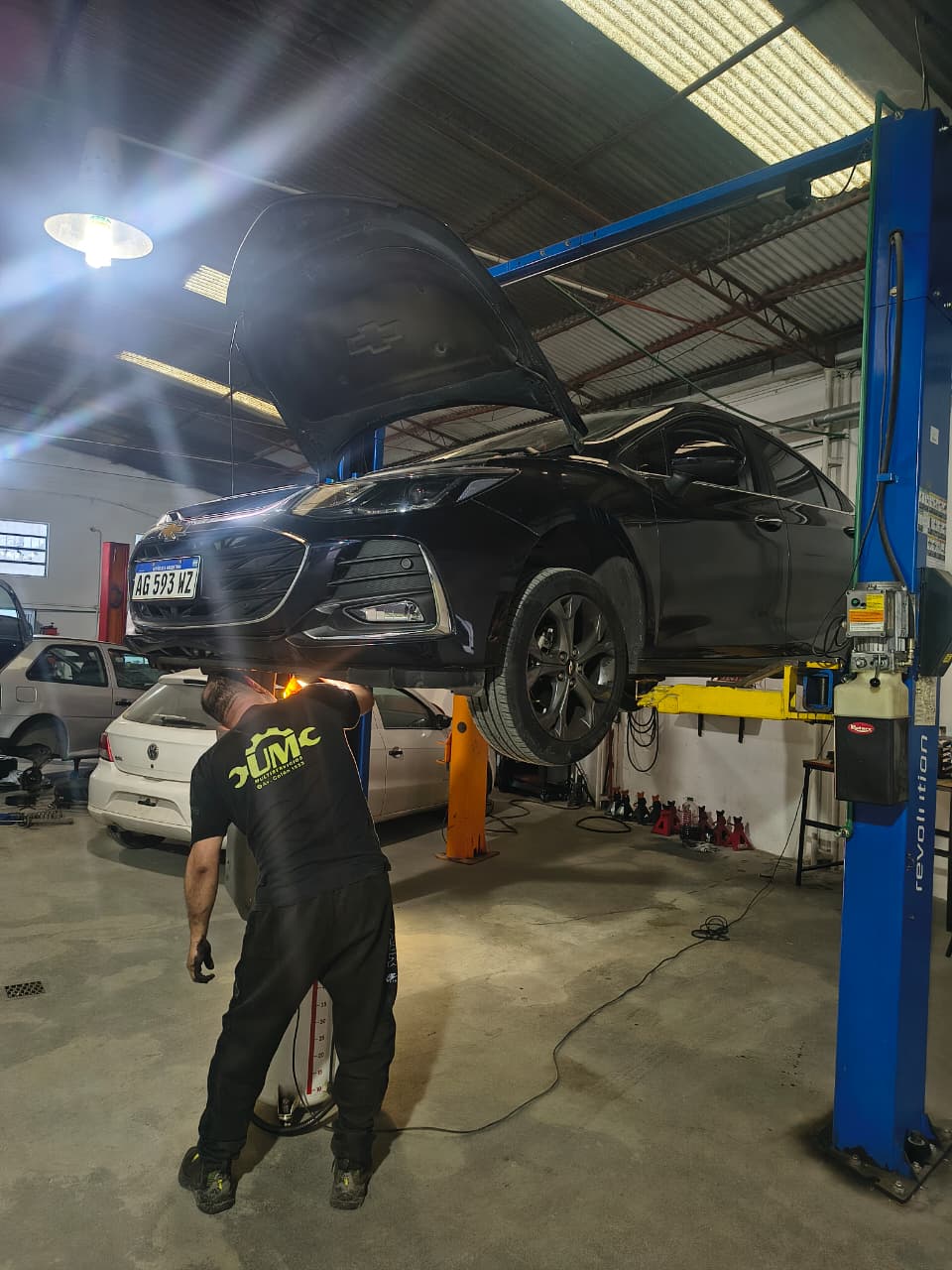 Mecánico trabajando debajo de un vehículo en la sucursal Octavio Pinto